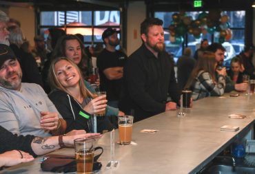 People enjoying beer seated at the bar