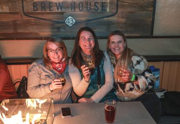 Women enjoying wine by the fire
